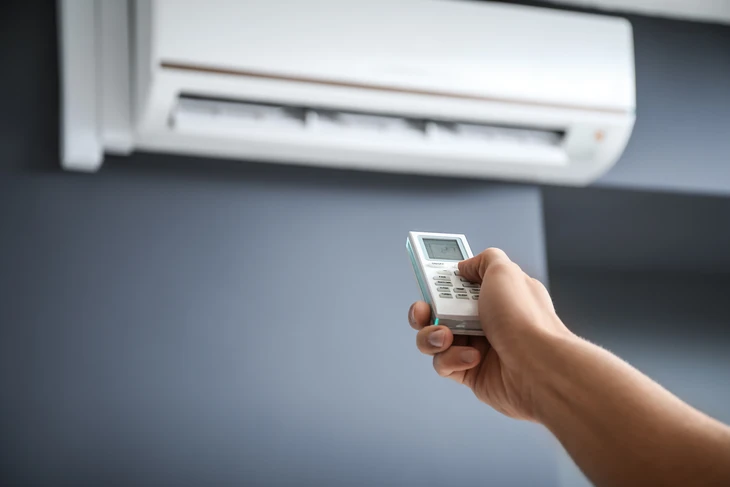 Ext&eacute;rieur r&eacute;sidentiel avec unit&eacute; ext&eacute;rieure de climatisation install&eacute;e contre un mur blanc
