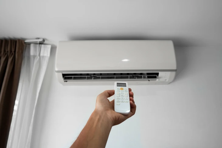 Intérieur moderne avec climatiseur mural blanc installé sur mur gris clair